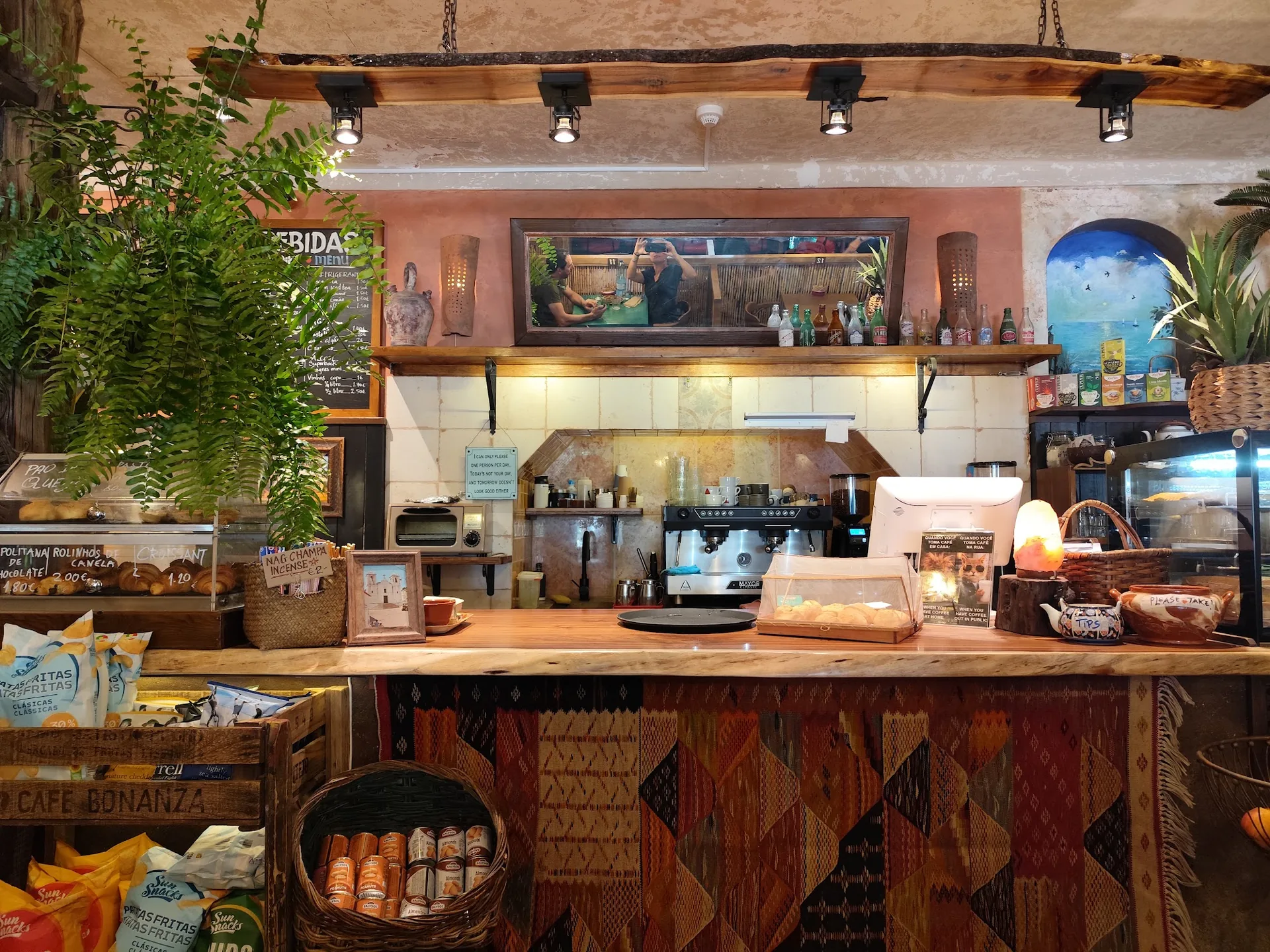 The wooden counter at Café Bonanza, with plants, coffee machine and woven fabric