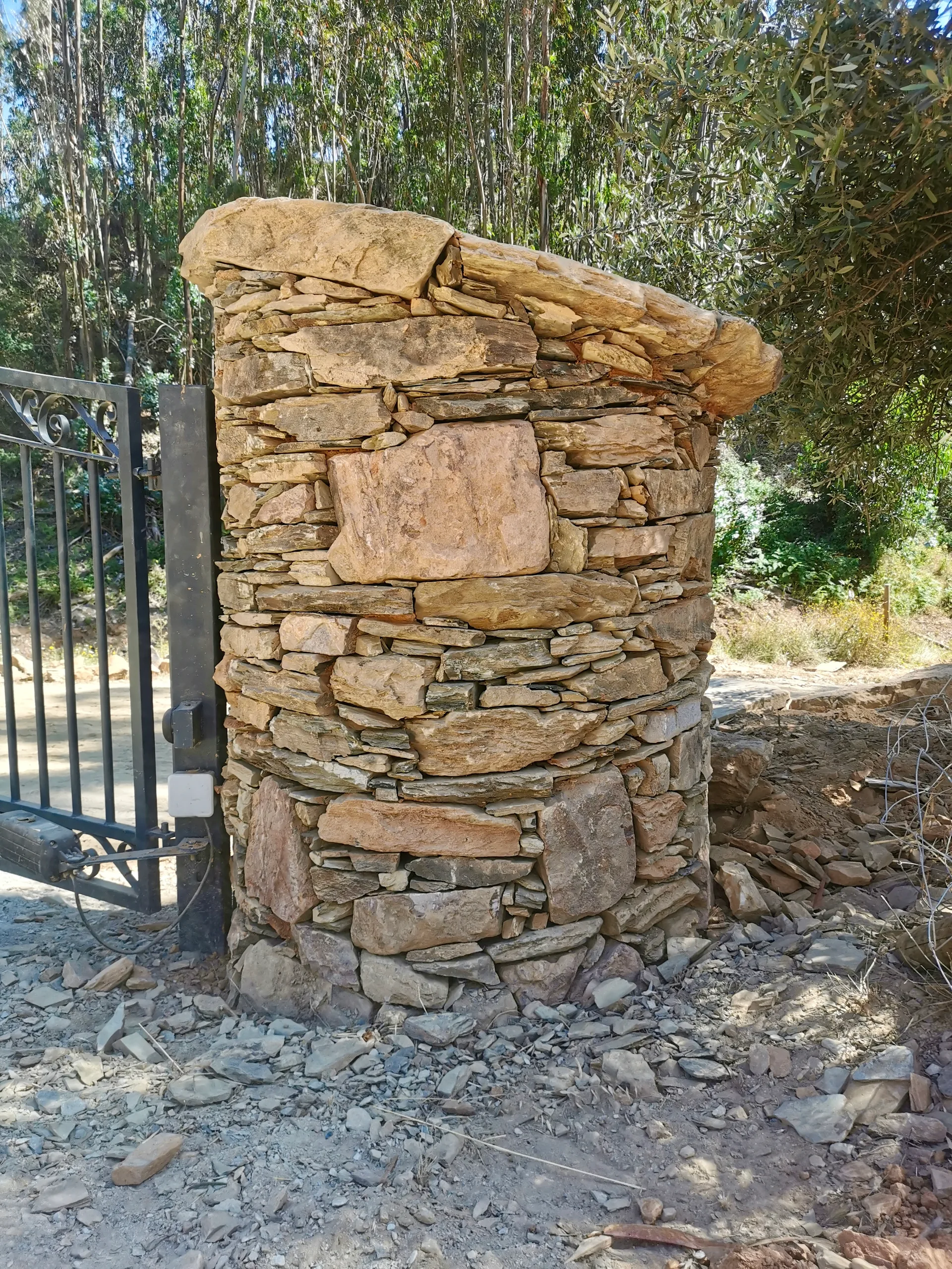 Round dry stone gate pillar in local schist